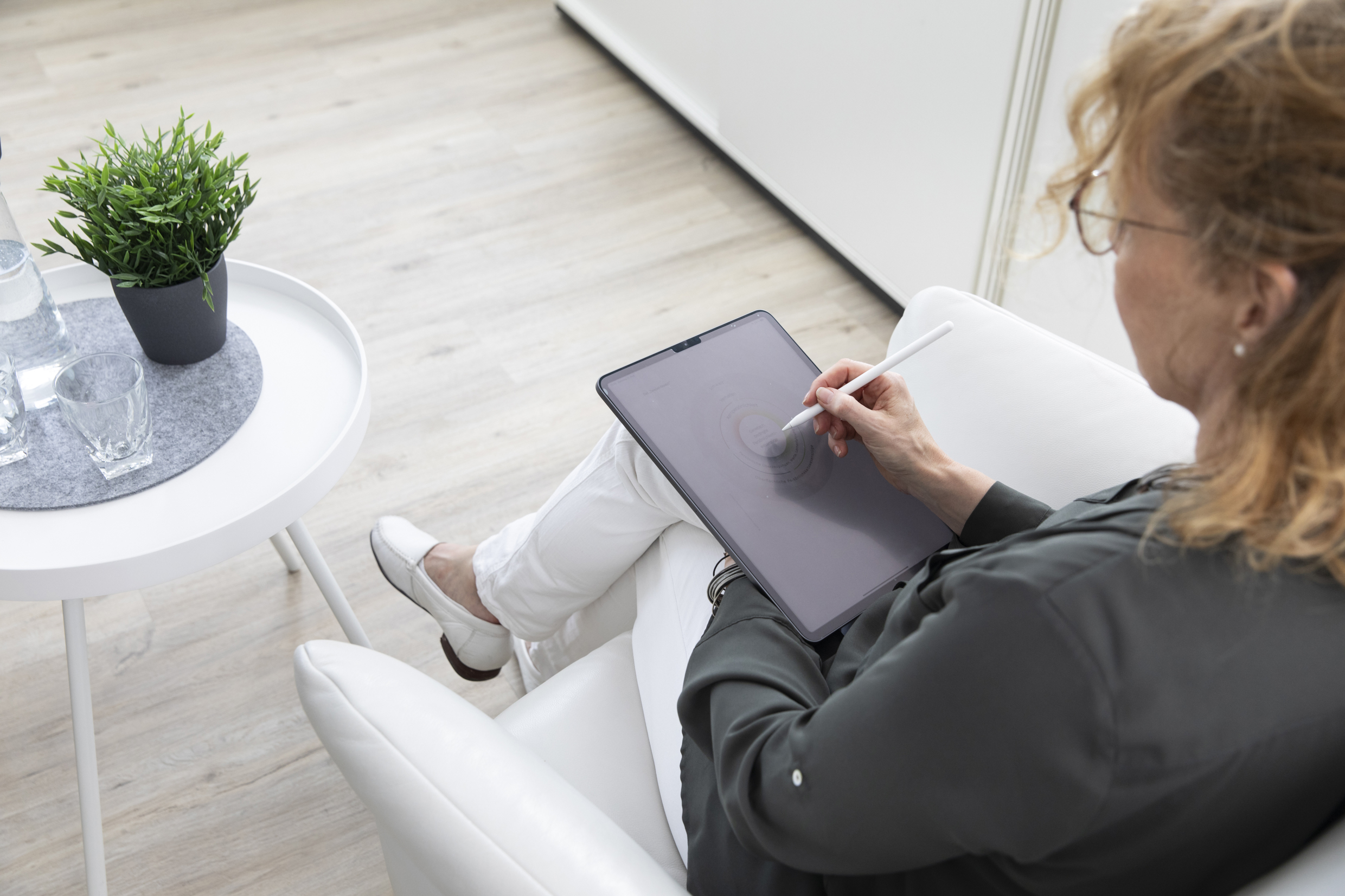 Dipl.-Psych.-Maya Diekmann-Business-Coach & Systemische Beraterin-Psychologische Psychotherapeutin-38 Maya Diekmann: Blonde Frau mit Brille schaut auf ihr iPad und bearbeitet etwas mit dem Stift.